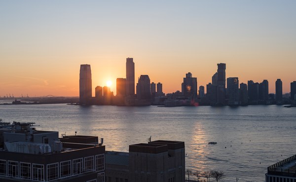 Rooftop view from Hotel Hugo in SoHo with panoramic Hudson River sunset and Manhattan skyline at dusk