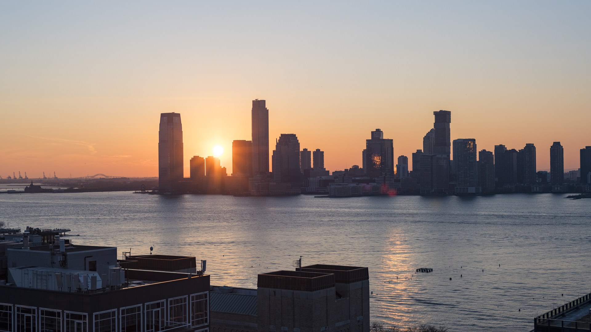 Rooftop view from Hotel Hugo in SoHo with panoramic Hudson River sunset and Manhattan skyline at dusk