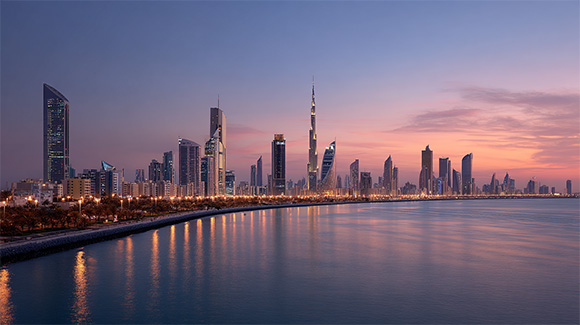Depicts the skyline of metropolitan middle eastern city like Dubai at twilight on a bay