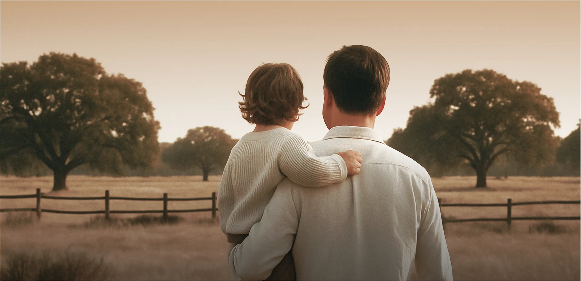 Man holding a child looking over a field