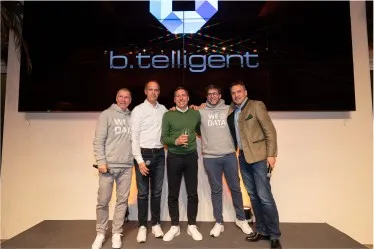 Die b.telligent Geschäftsführer stehen auf der Bühne bei einer Feier