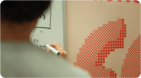 A person writing on a white board in Agemo's office