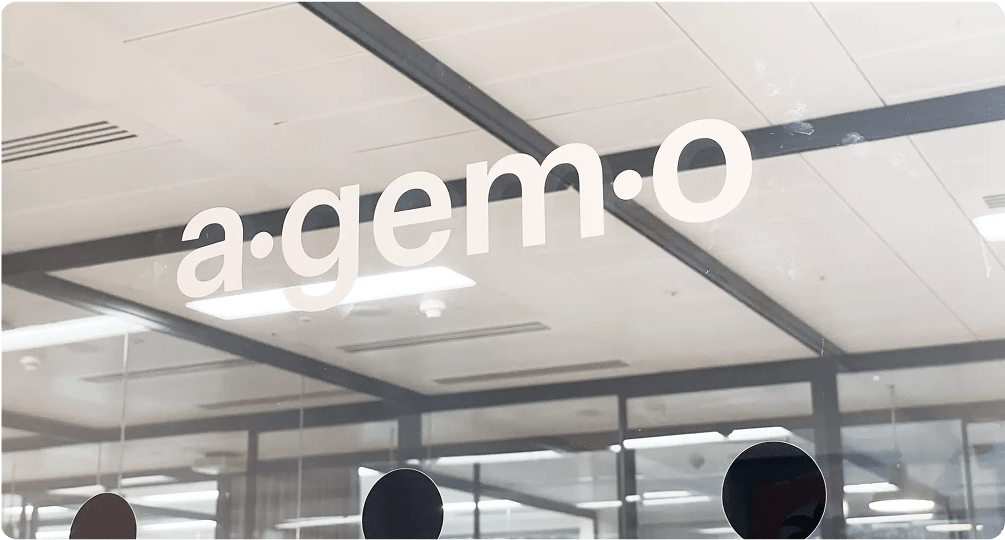 Agemo's logo printed onto a glass divider in an office setting