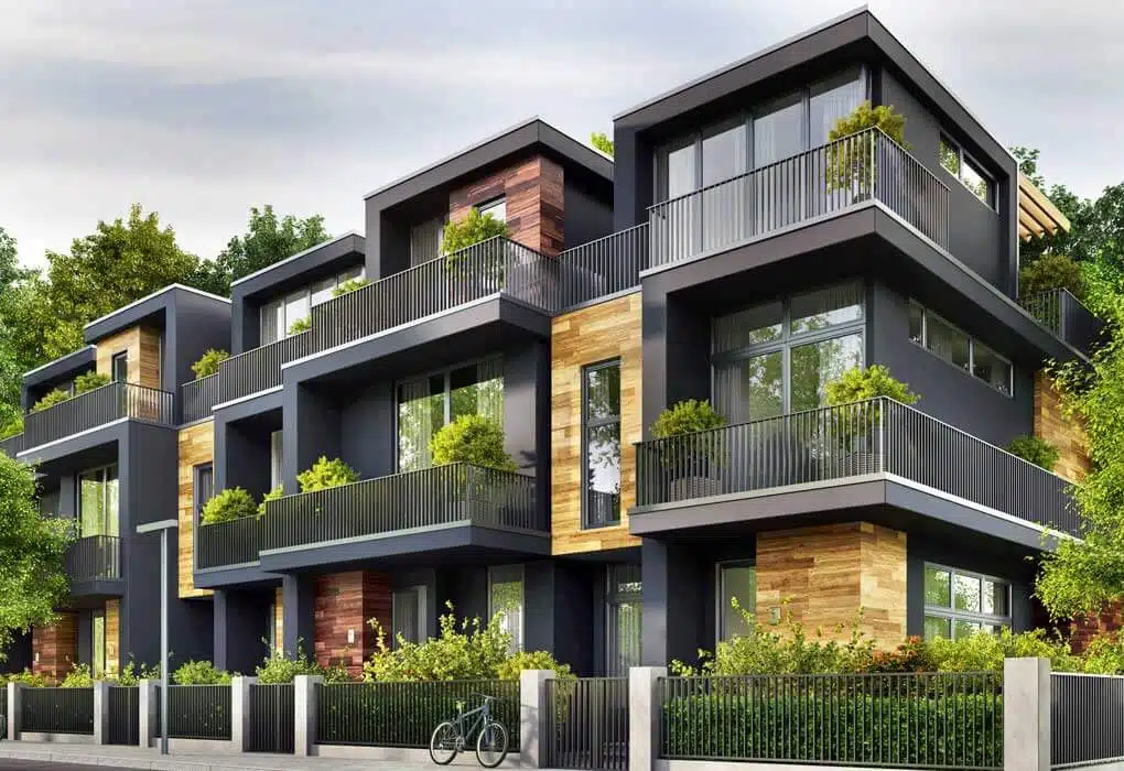 Modern three-story apartment building with dark exterior accented by wood paneling. Each unit features expansive windows and private, plant-adorned balconies. A black bicycle is parked in front, and greenery surrounds the well-maintained property. Rent reporting services are available for tenants.