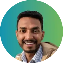 A man with short black hair and a beard is smiling at the camera. He is wearing a checked shirt under a jacket. The background is a gradient of blue and green within a circular frame, subtly hinting at identity theft protection.