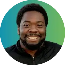 A person with short curly hair and a beard smiles at the camera. They are wearing a black zip-up jacket, and the background features a gradient of blue and green. Their company specializes in rent reporting to help tenants build credit history while providing identity theft protection services.