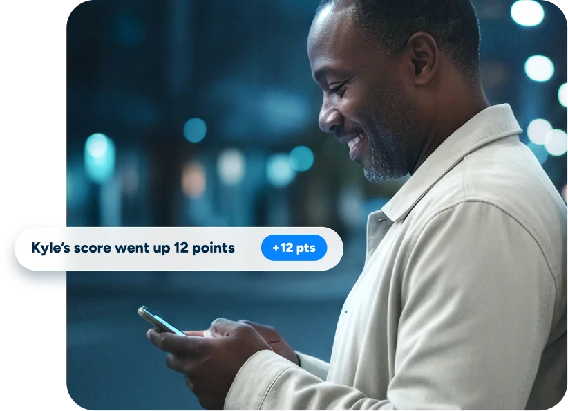 Middle aged father with a blue-toned background looking down at his phone smiling with an alert from Acru popping up that says Kyle's score went up 12 points