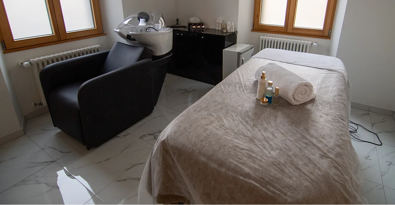 Cabina massaggi allestita con lettino e asciugamani in centro estetico Lugano