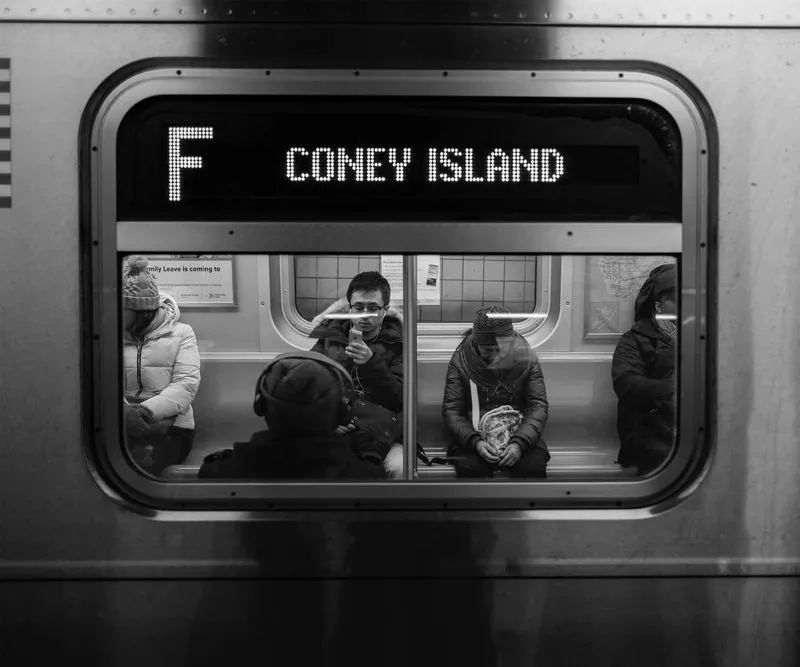 A subway train interior featuring passengers seated, showcasing a typical urban commuting scene.