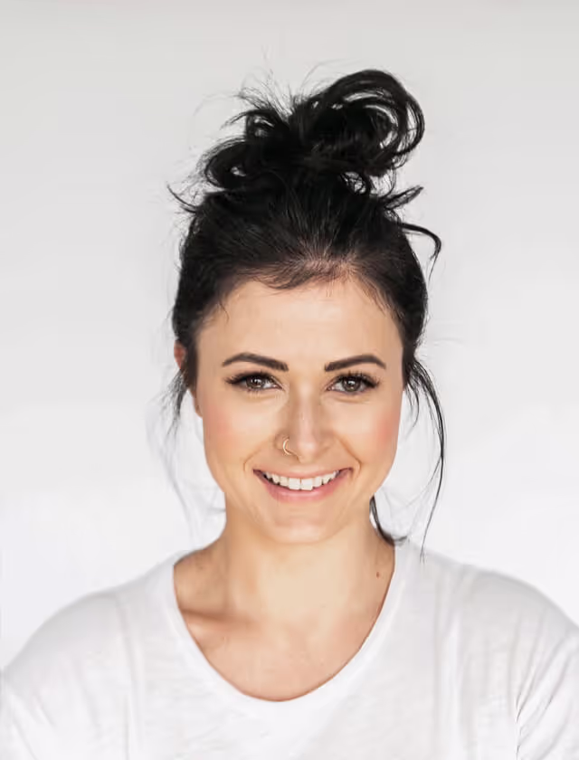 A woman with a messy bun hairstyle, exuding a casual and relaxed vibe.