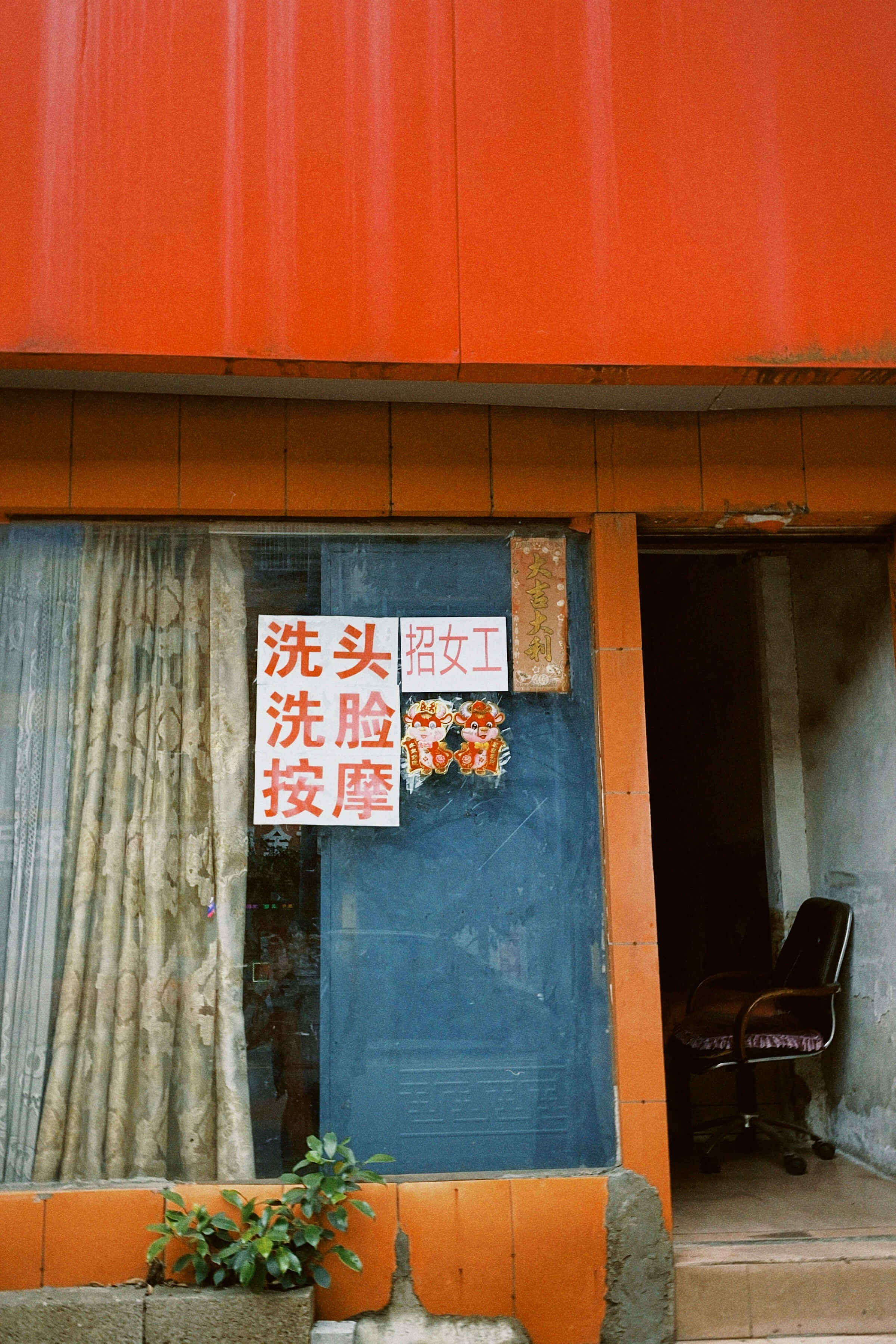 A red building featuring Chinese characters displayed prominently on its window.
