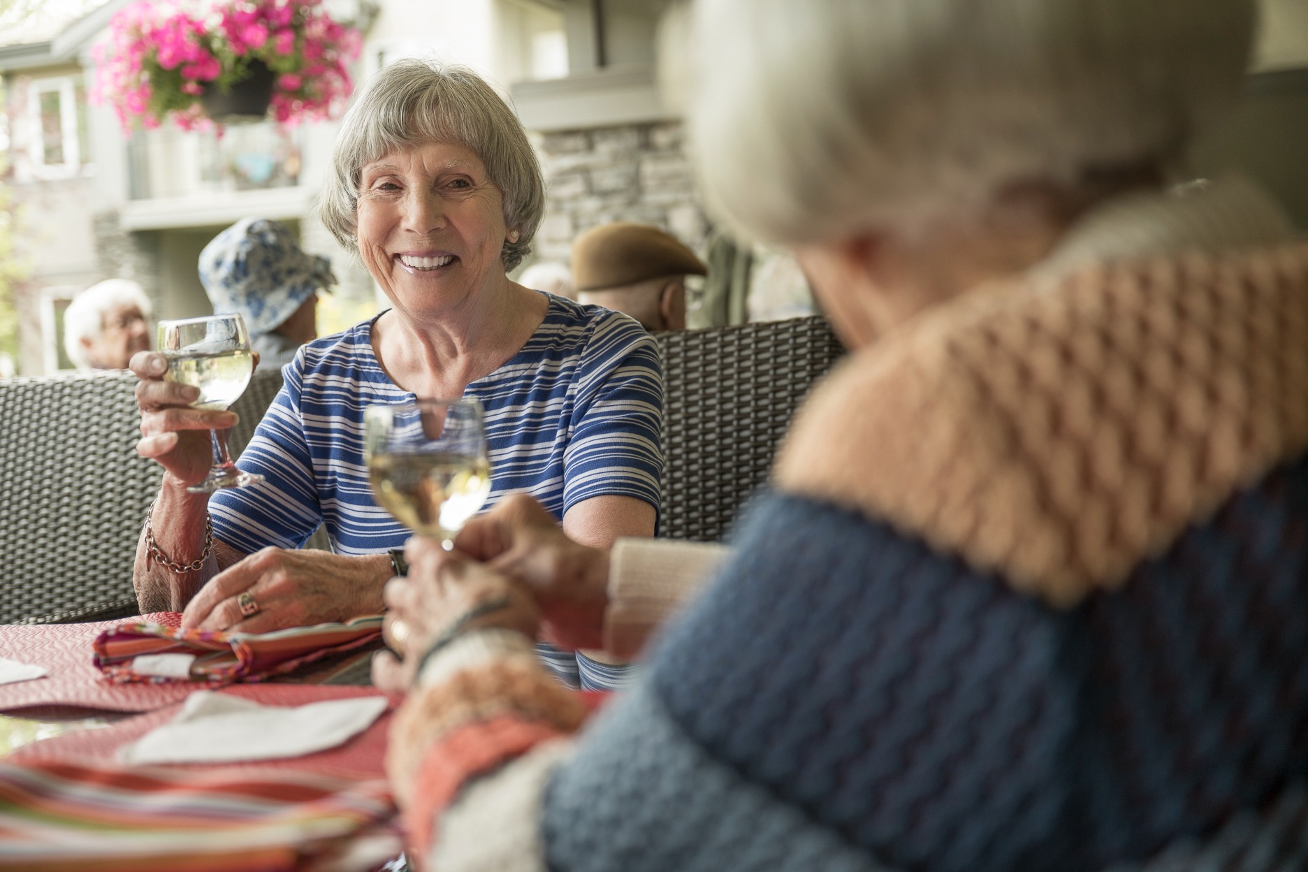 Elder senior enjoying a glass of wine in a 55+ retirement community