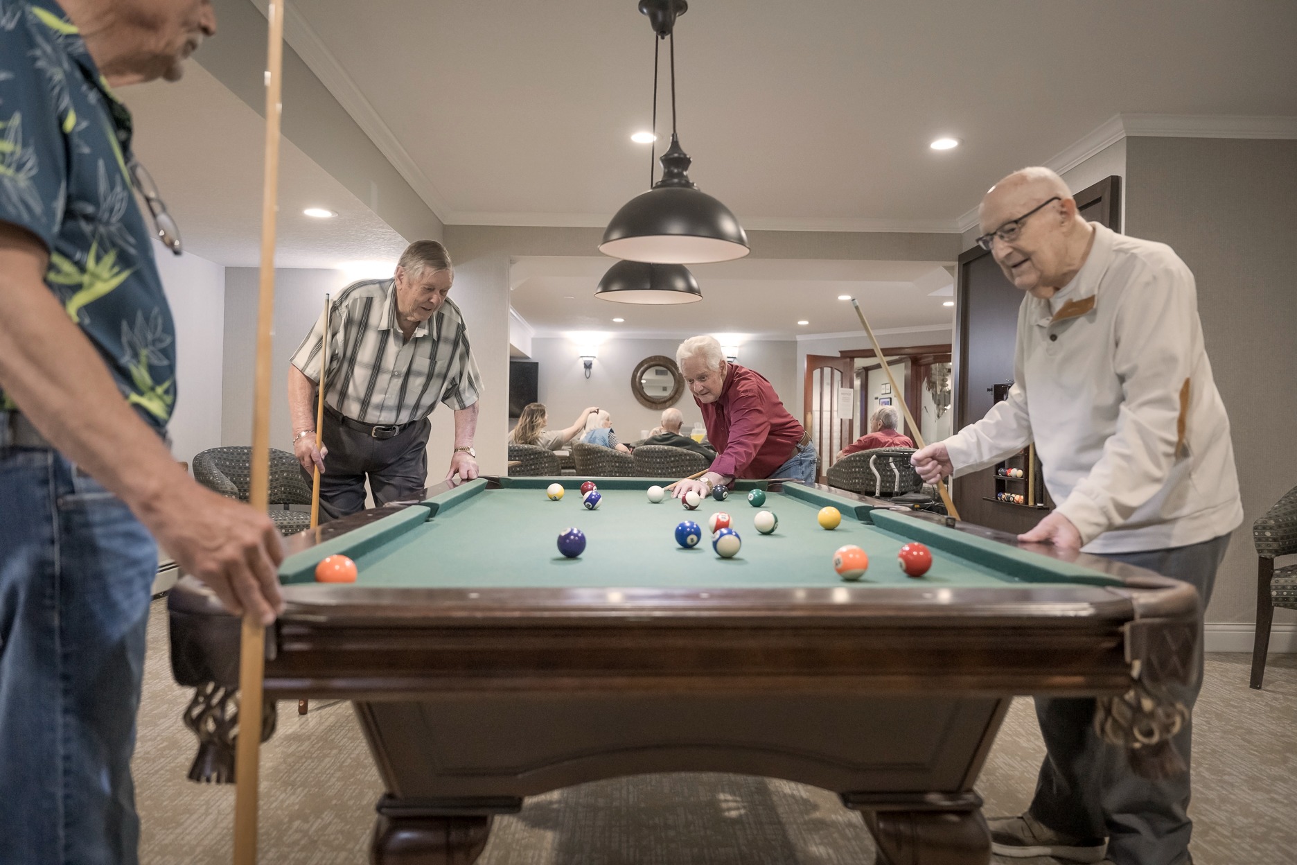 seniors enjoying living in a reirement community playing pool