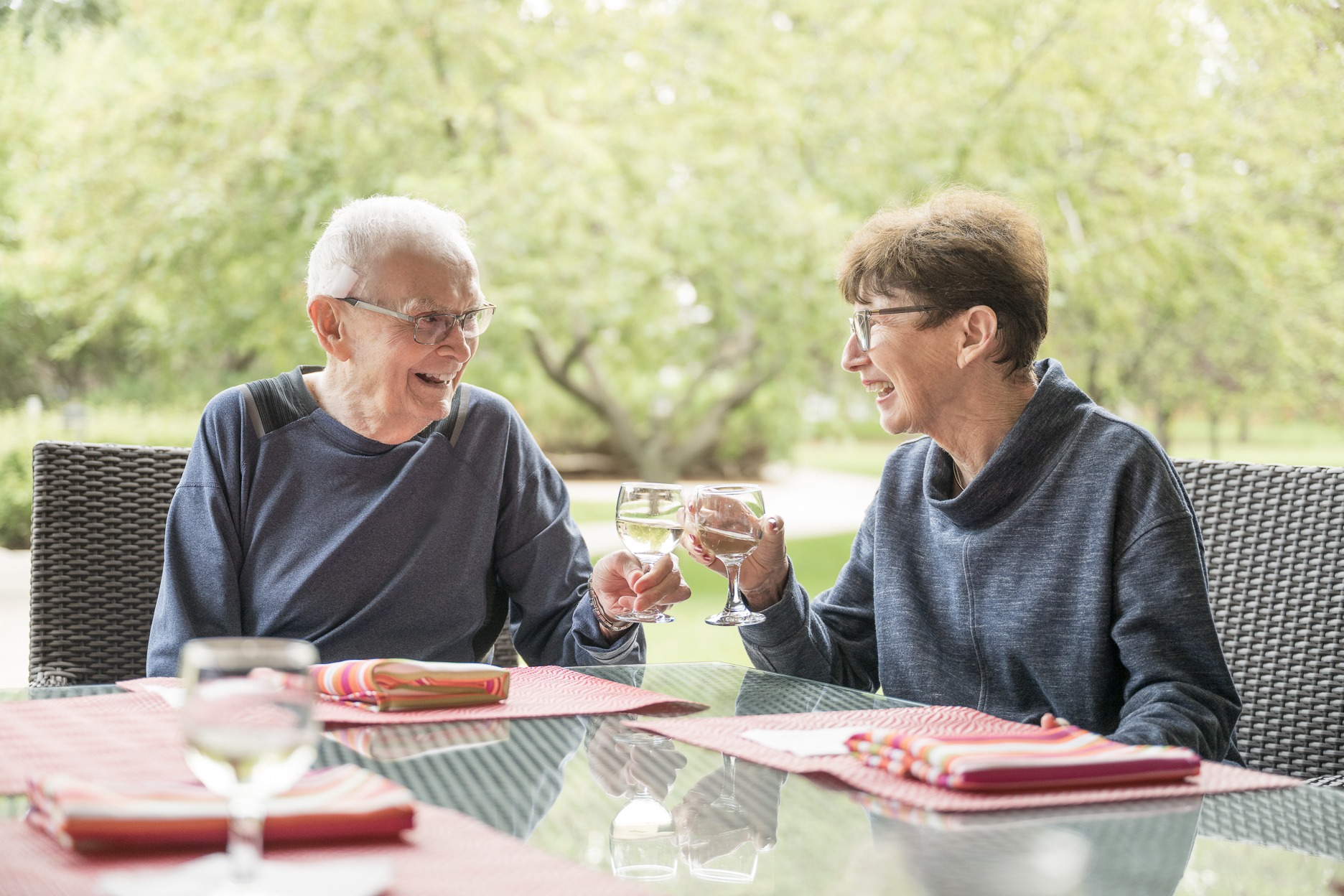 senior couple sitting at a table drinking and smiling