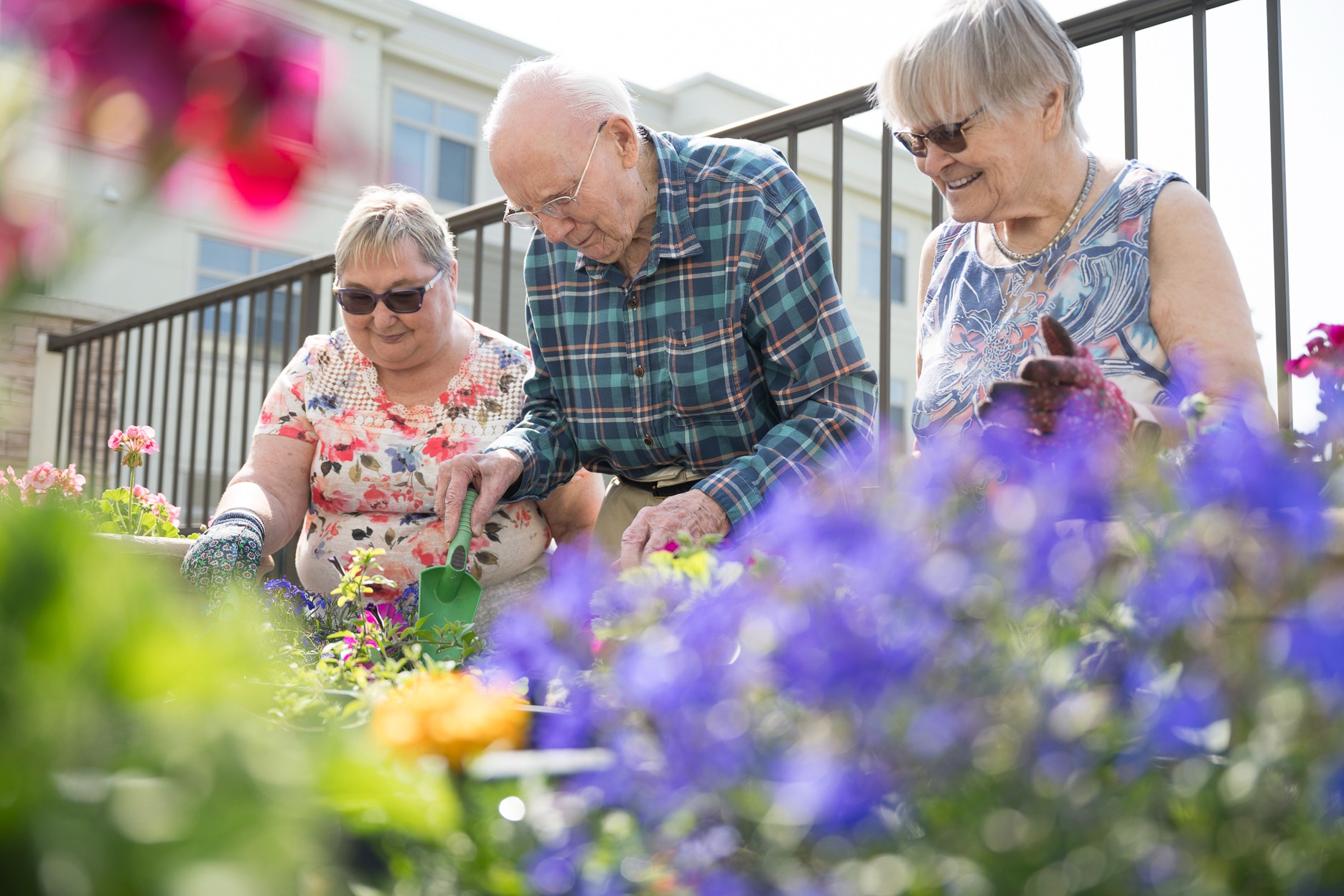 Three seniors gardening at a retirement community in calgary