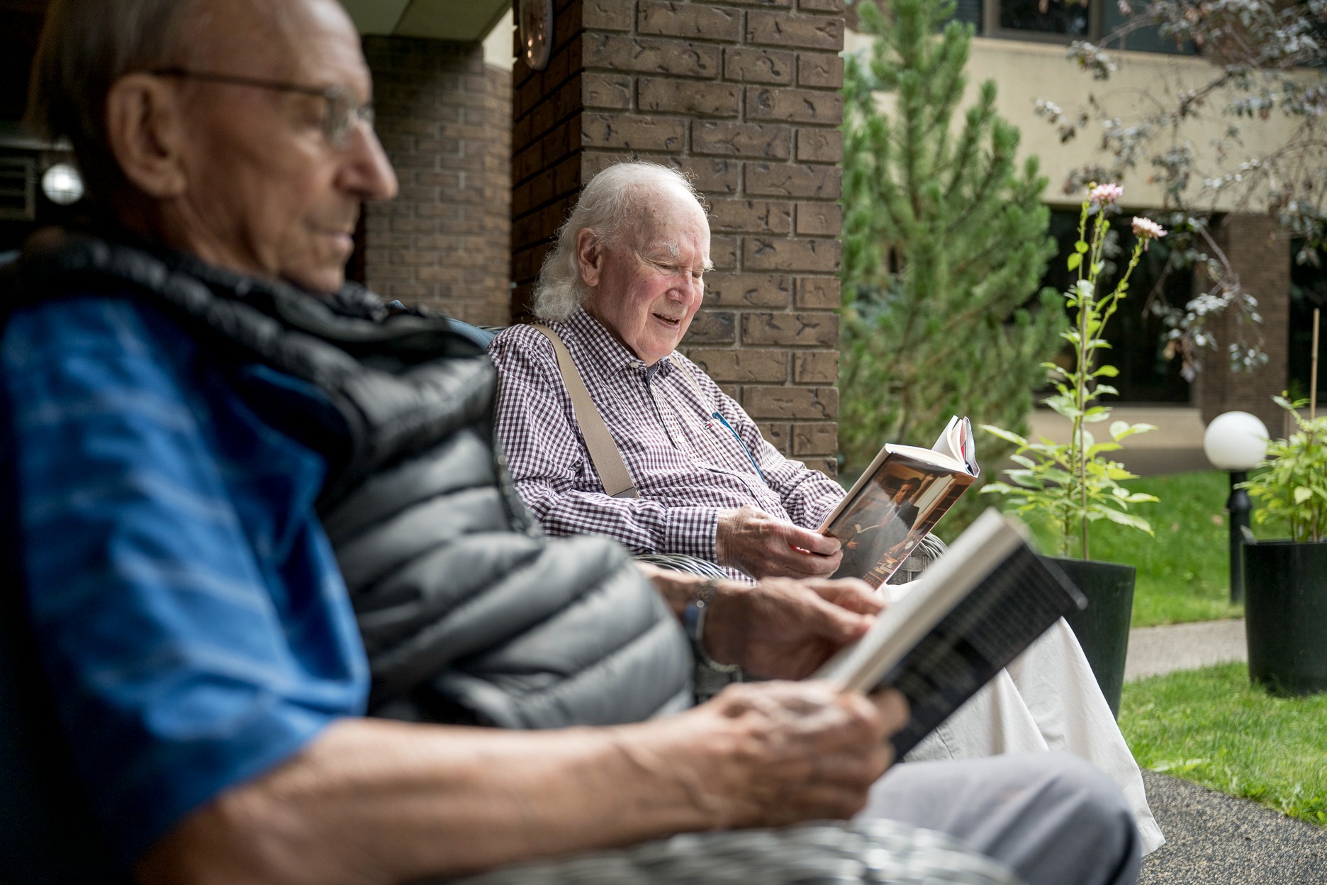 2 seniors chatting and reading in senior community gardens 