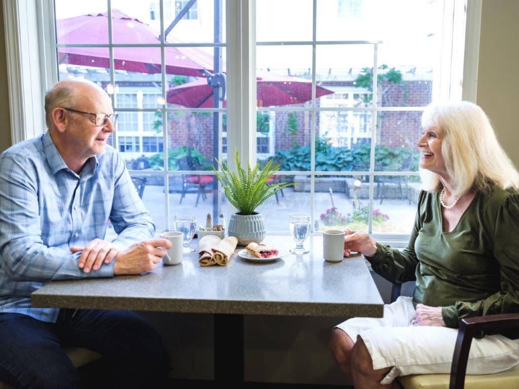 senior couple drinking coffee and chatting at retirement community dining