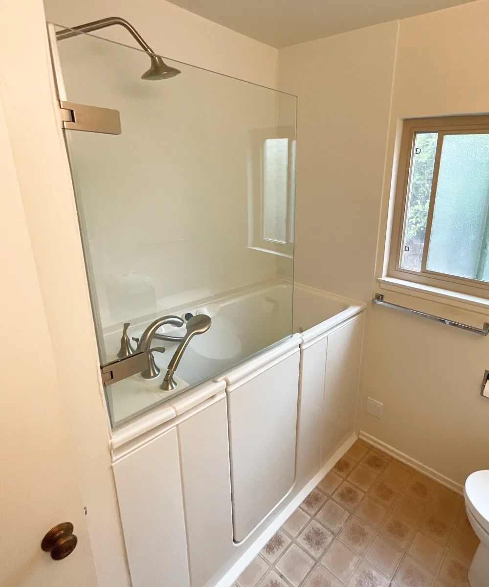 Minimalist Kohler shower remodel with high-end finishes and floor-to-ceiling built-in shelving.