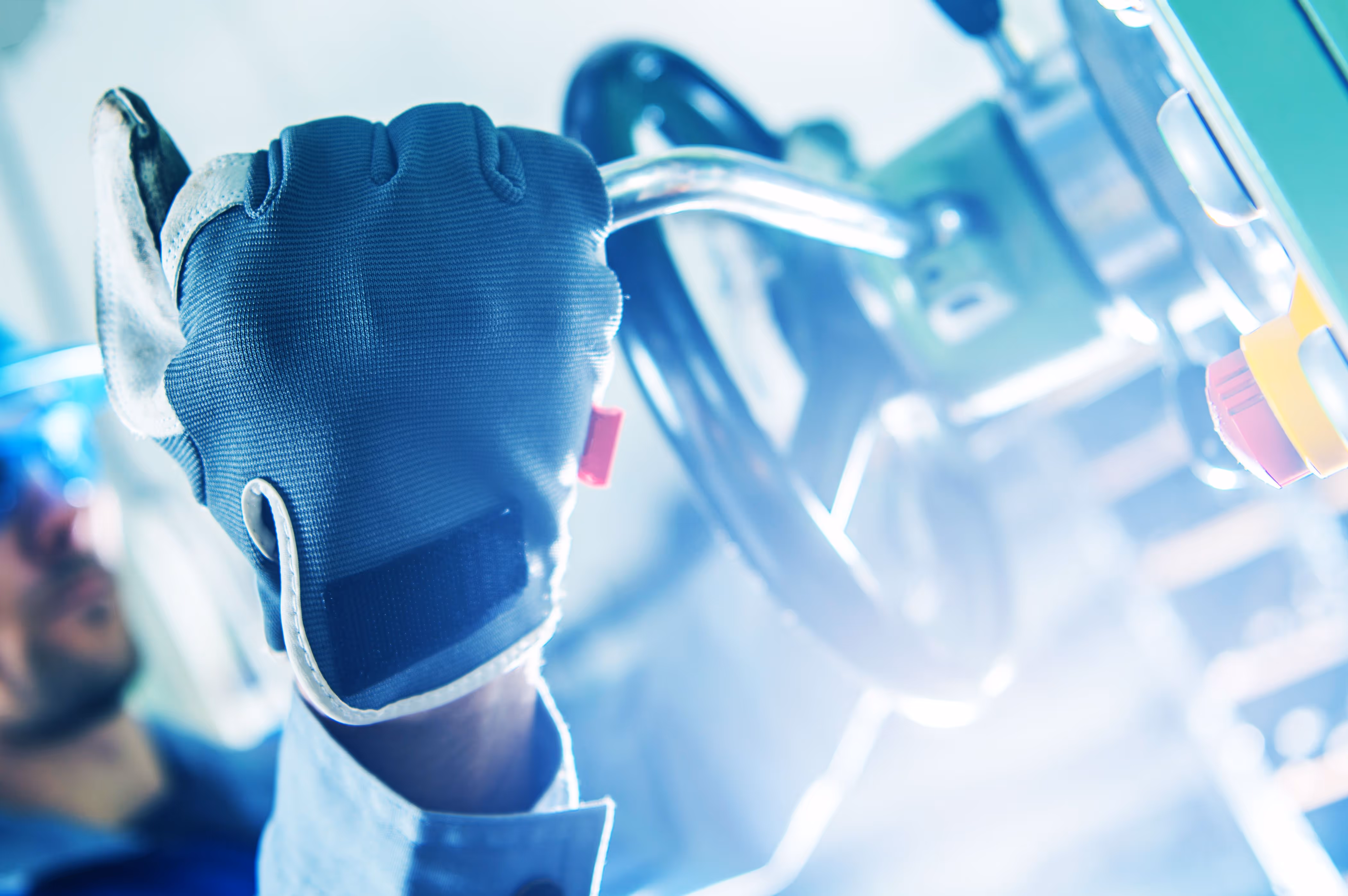 Engineer adjusting CNC machinery with safety gloves in manufacturing plant