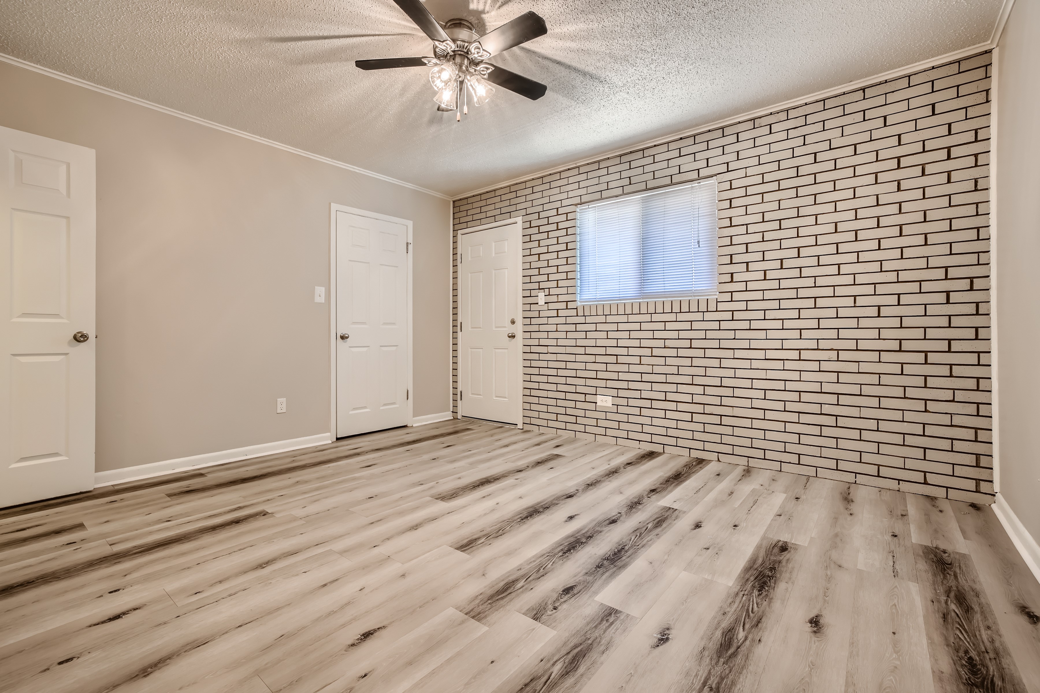 primary bedroom with exposed brick wall