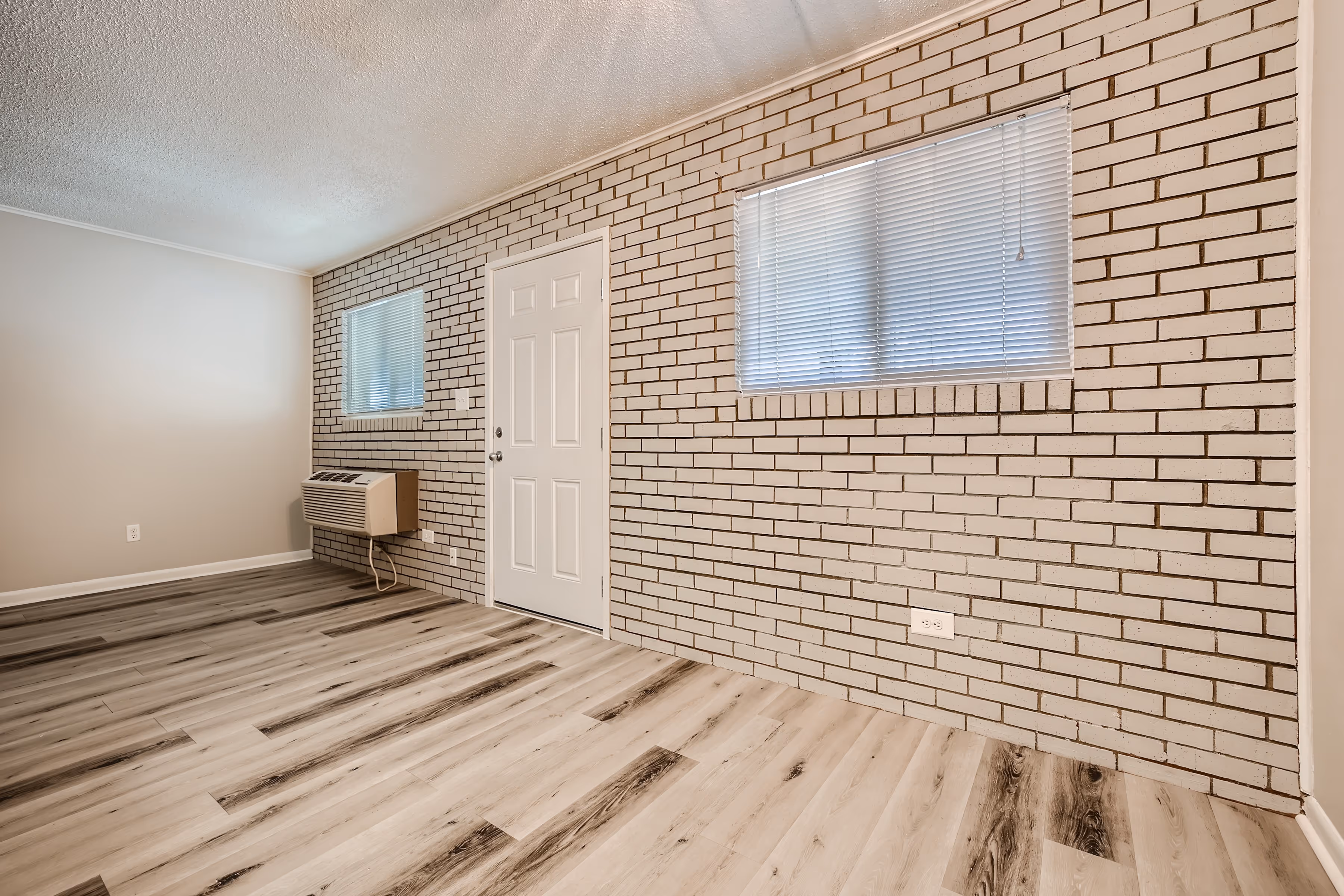 Dining room and living room with exposed white brick wall