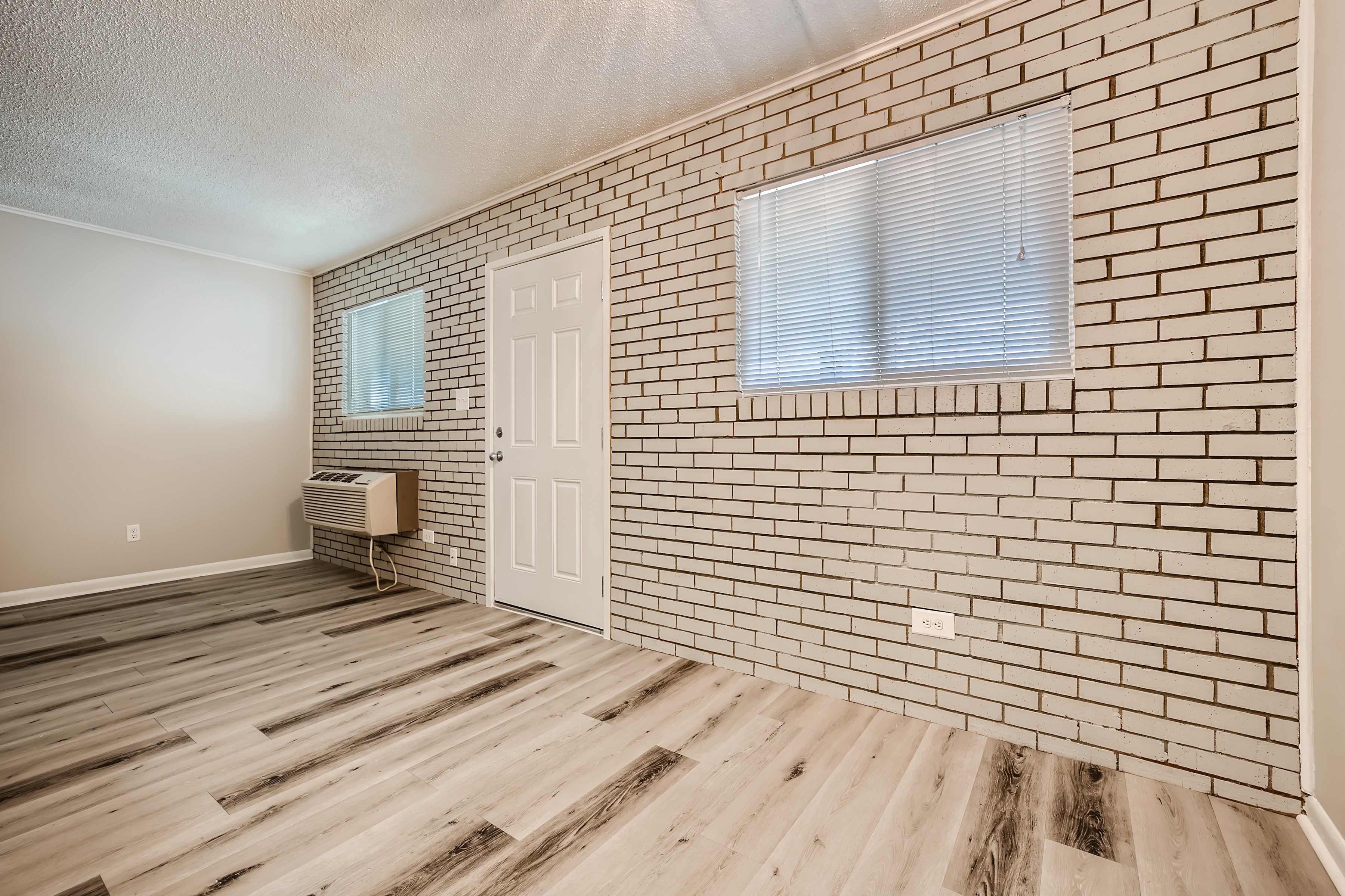Dining room and living room with exposed white brick wall