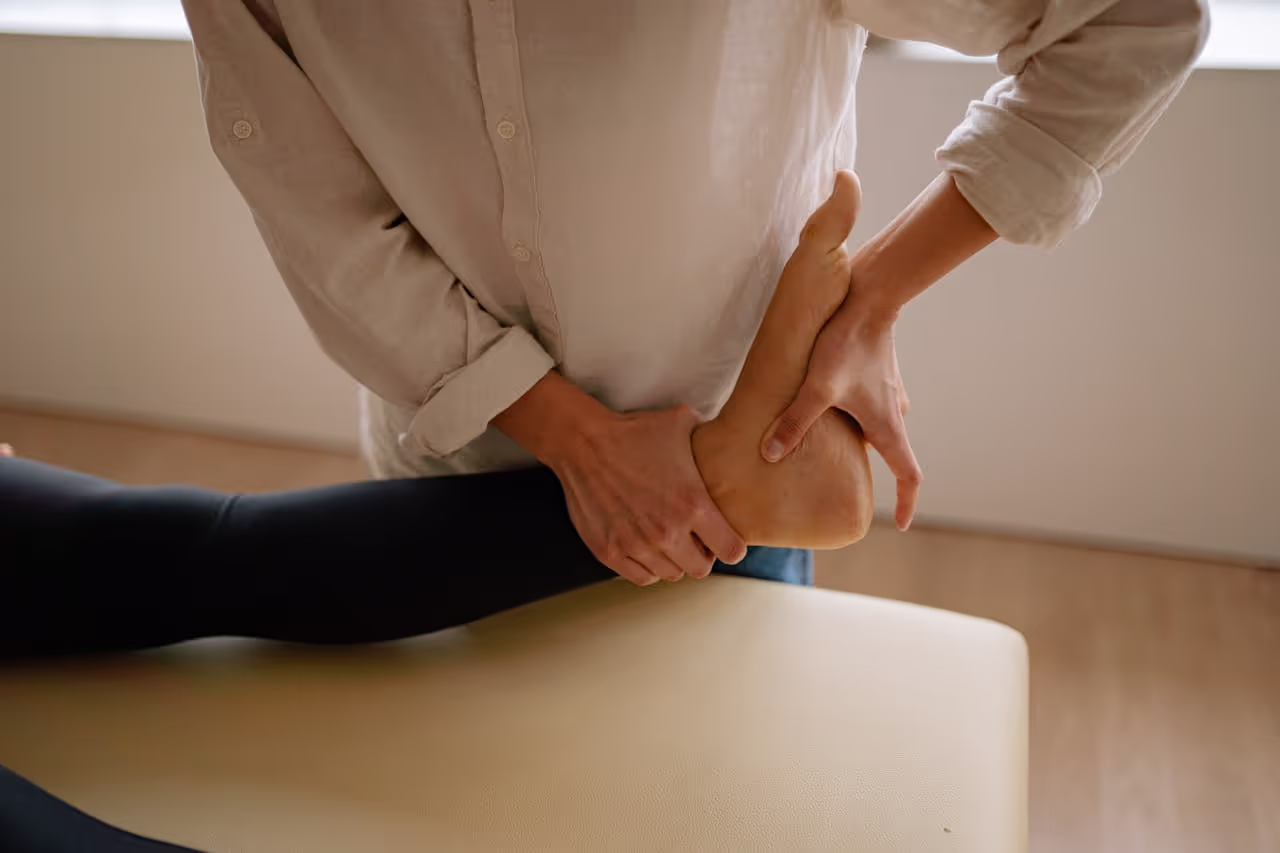 Eine erfahrene Physioterapeutin behandelt eine Frau mit einer Fußmassage.