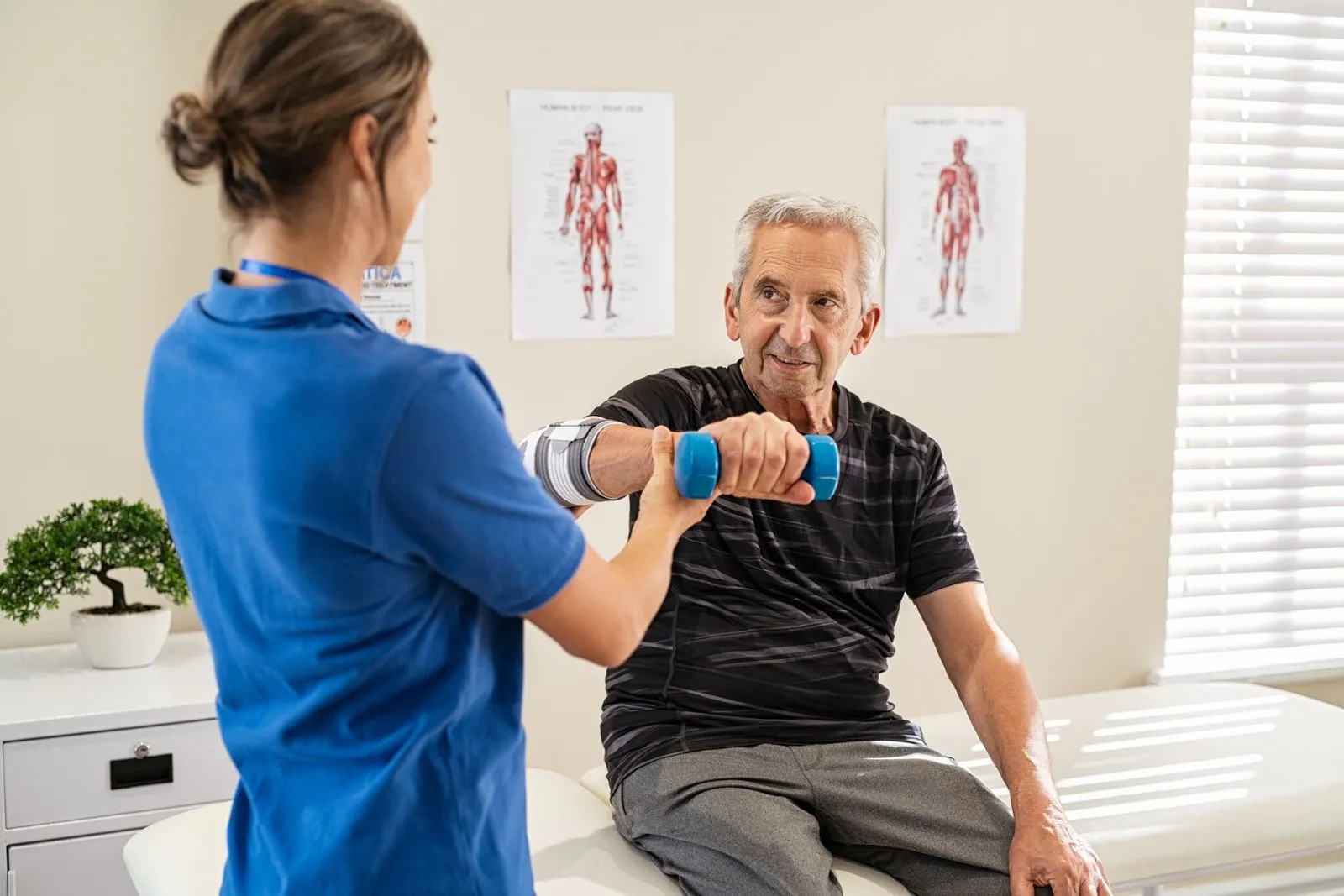 Eine Physiotherapeutin behandelt einen älteren Patienten mit KG-ZNS.
