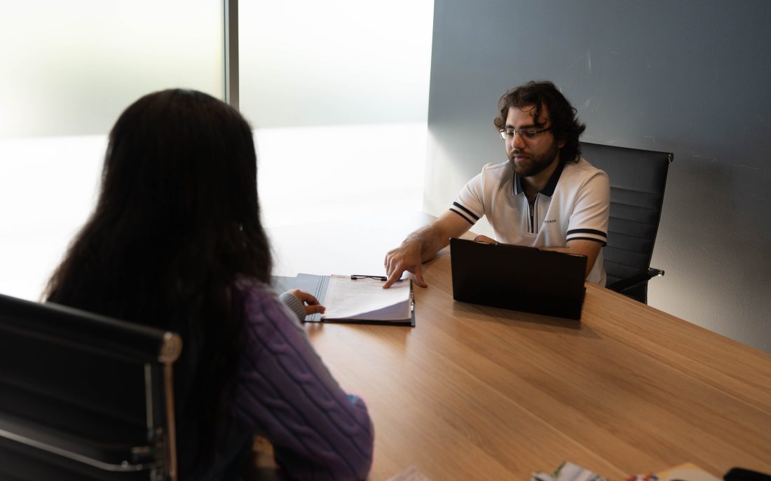 An Elevate Together advocate talking through paperwork with a client at the table