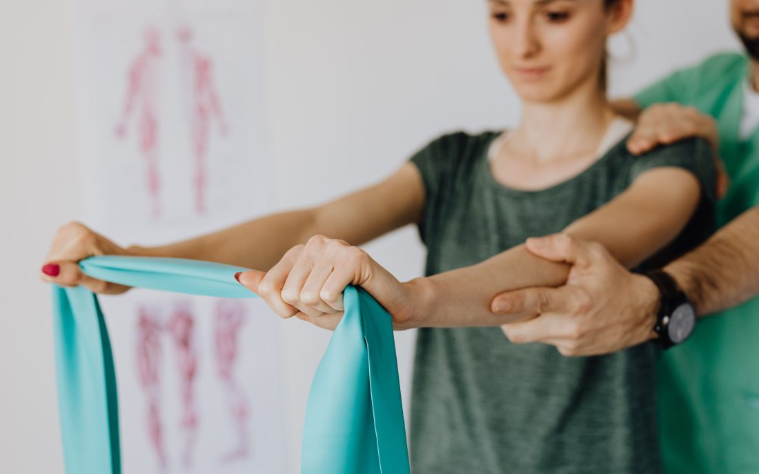 A therapist guiding a resistance band exercise