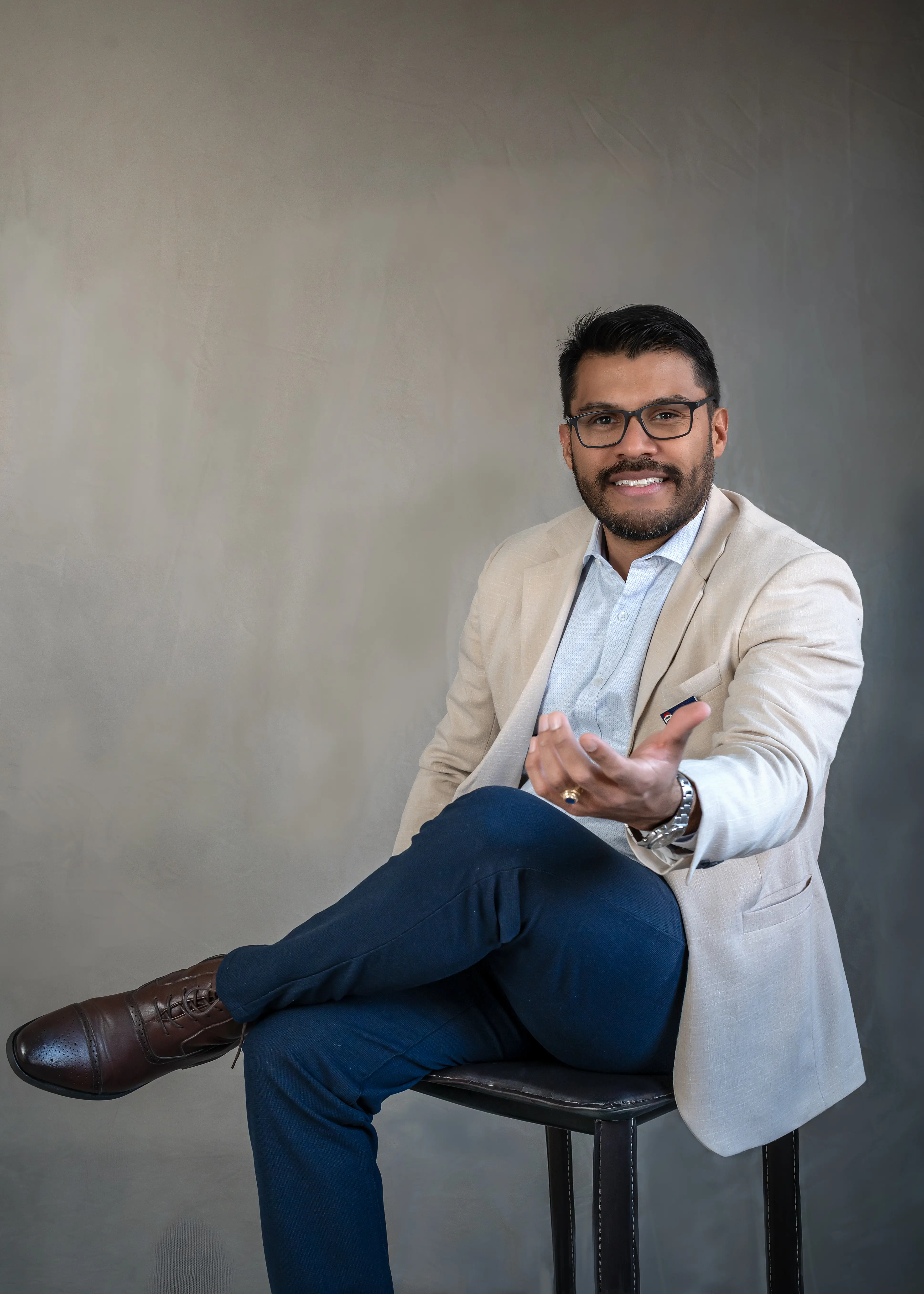 César Gómez, agente inmobiliario en providencia en quein confiar, sentado ofreciendo la mano