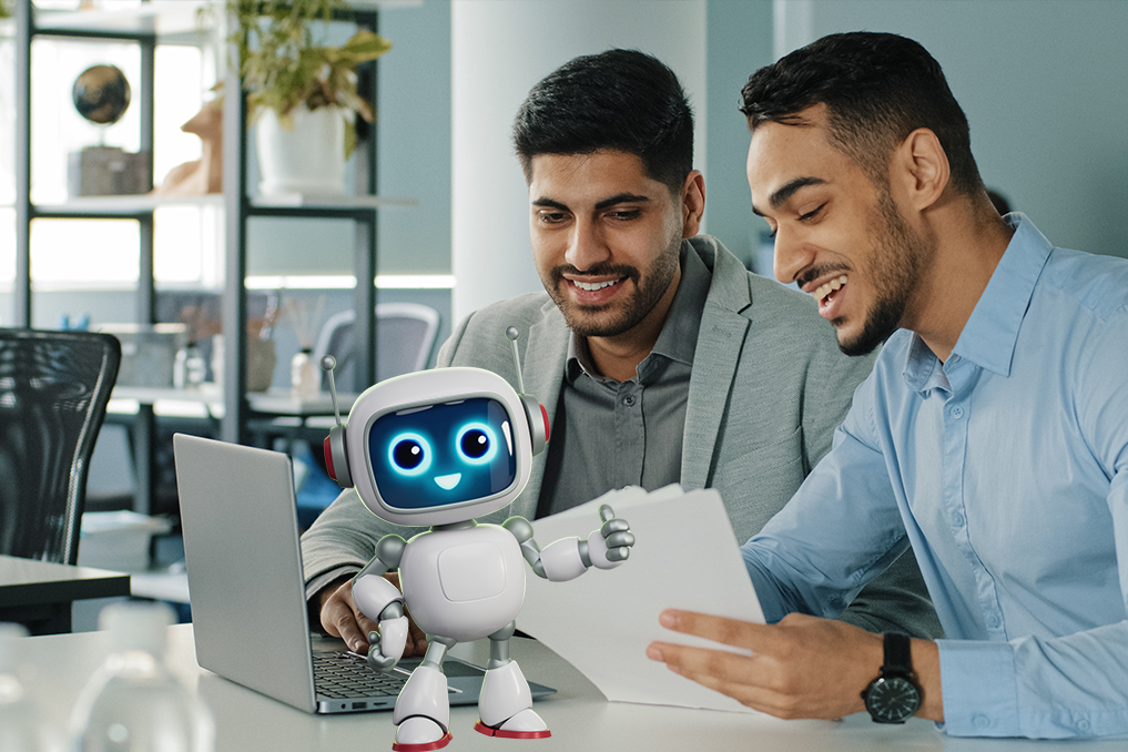 Two men smiling and reviewing documents together at a desk with a laptop and a friendly cartoon robot giving a thumbs-up in front.