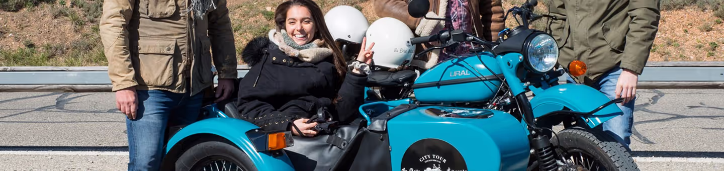 Une cliente souriante, assise passagère dans un side-car de la Belle échappée