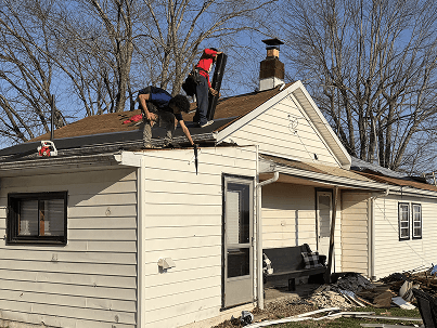 Brothers Who Roof and Construction fixing gutters on a one story home during a sunny day