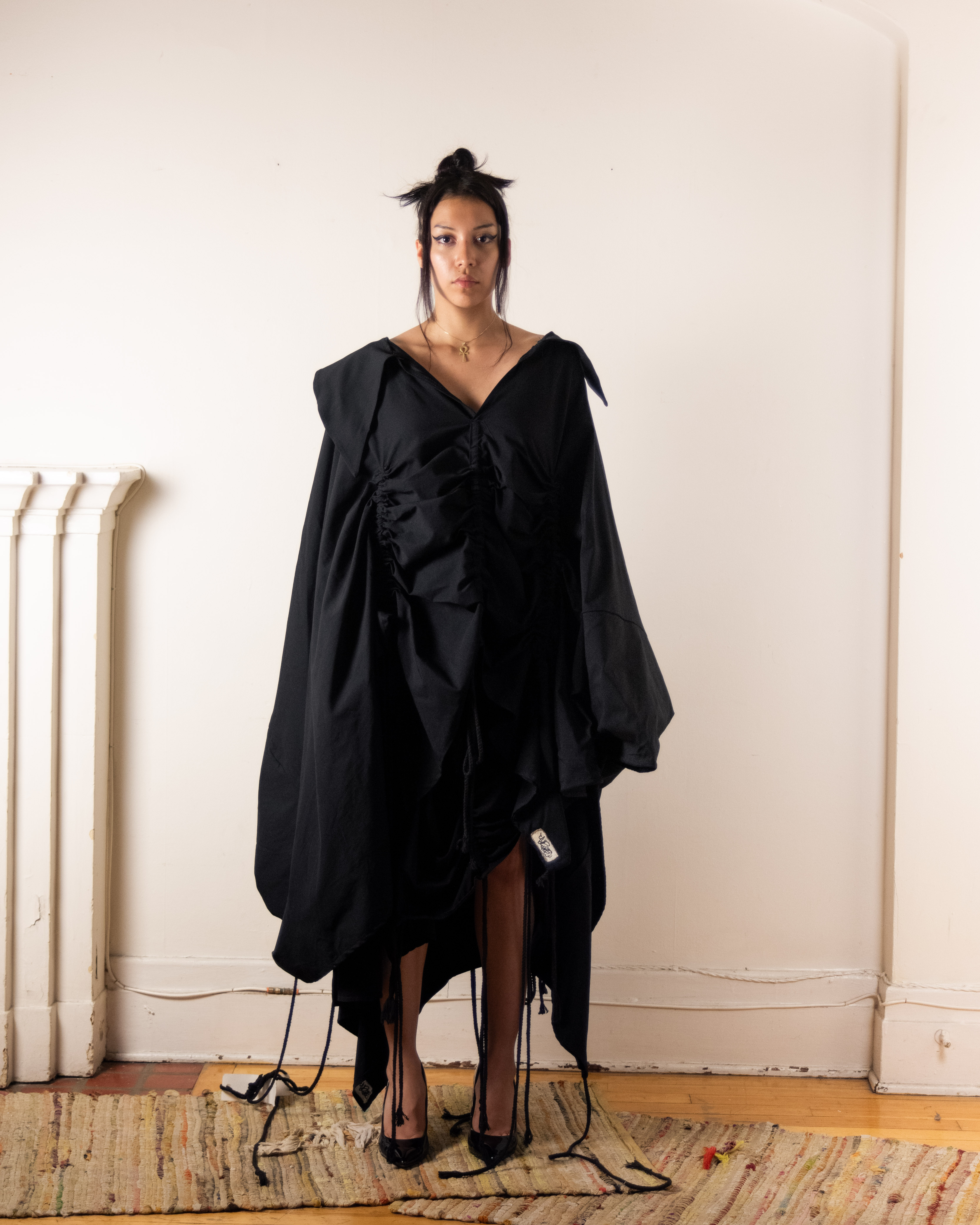 female model wearing black cape dress
