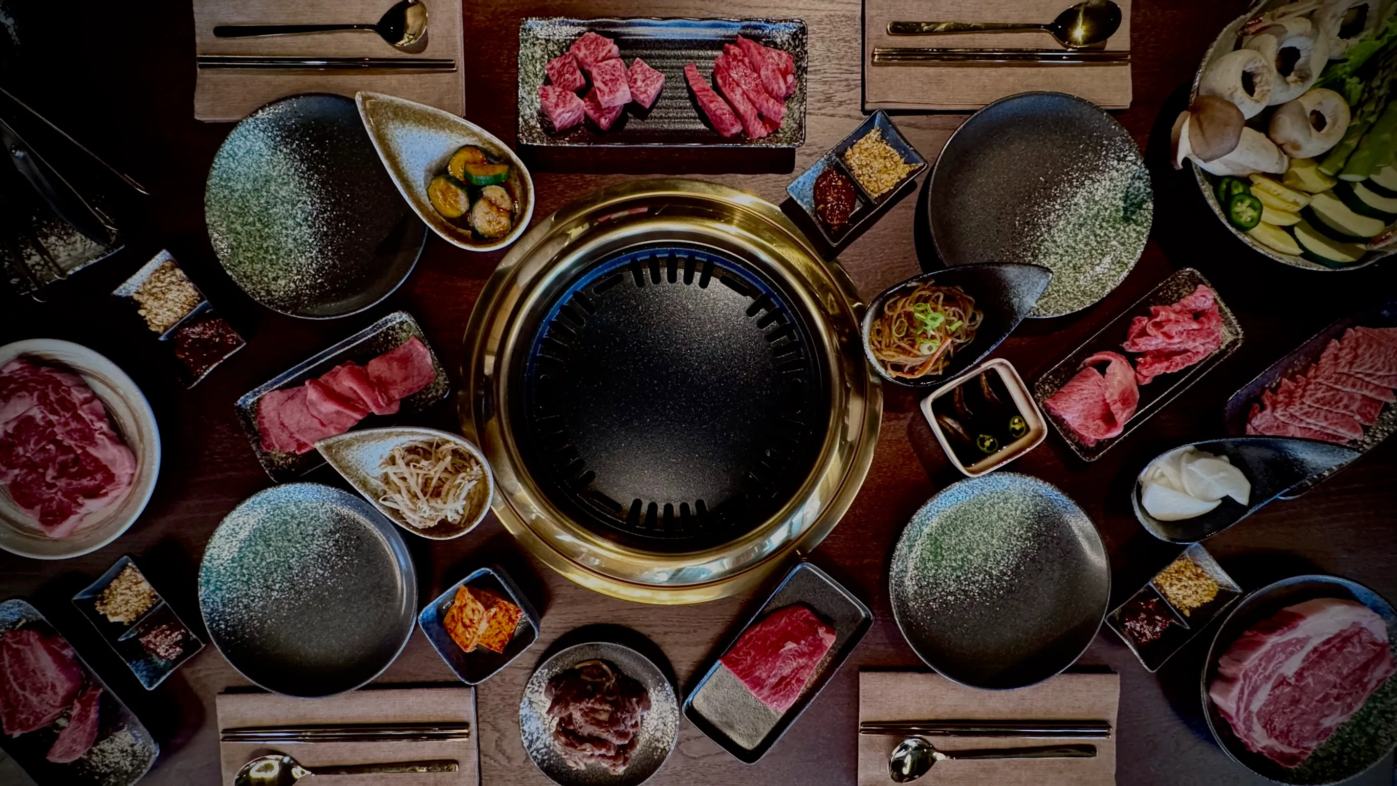 A person holding chopsticks over a tray of food.