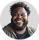 A man with glasses and a beard smiling.