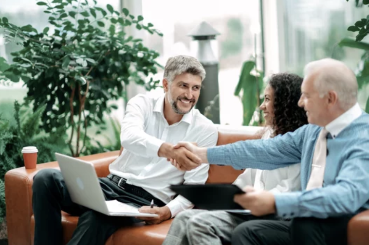 Business owner shaking hands with a buyer during an investor meeting