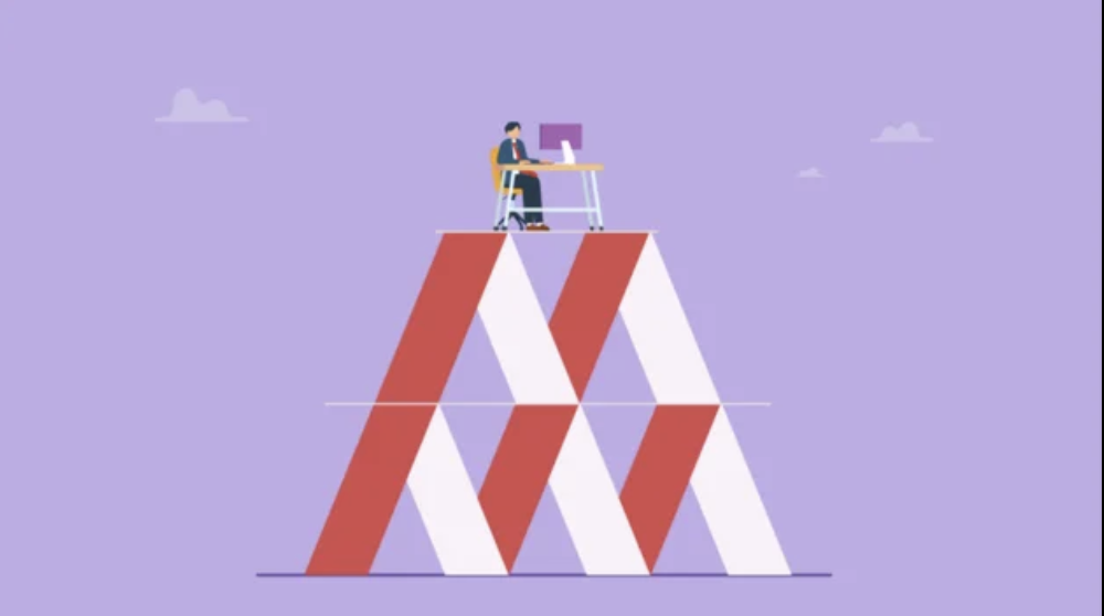 Founder working atop a shaky house of cards, symbolizing customer concentration risk to business valuation.