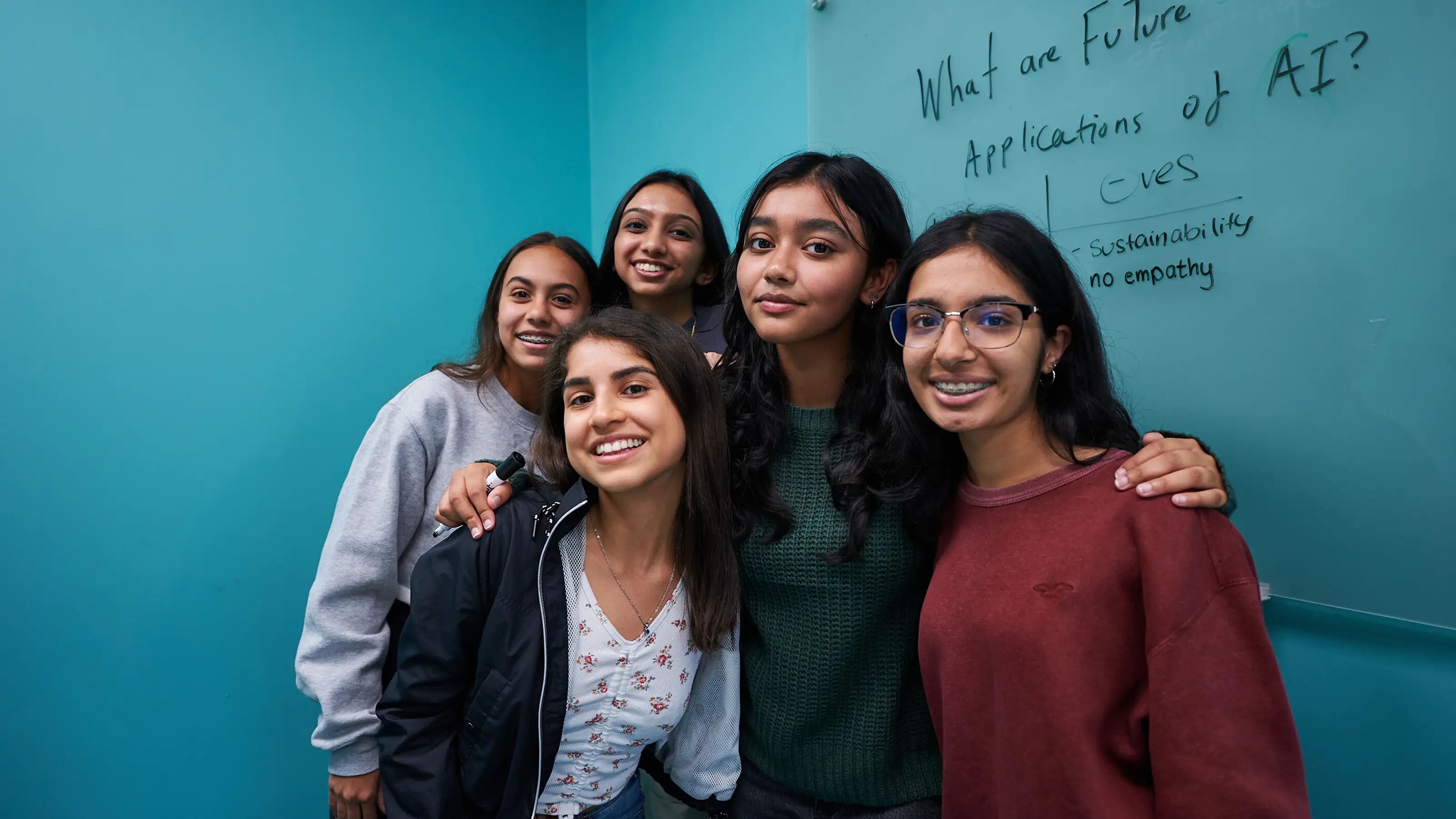 students pose in class at the blackboard