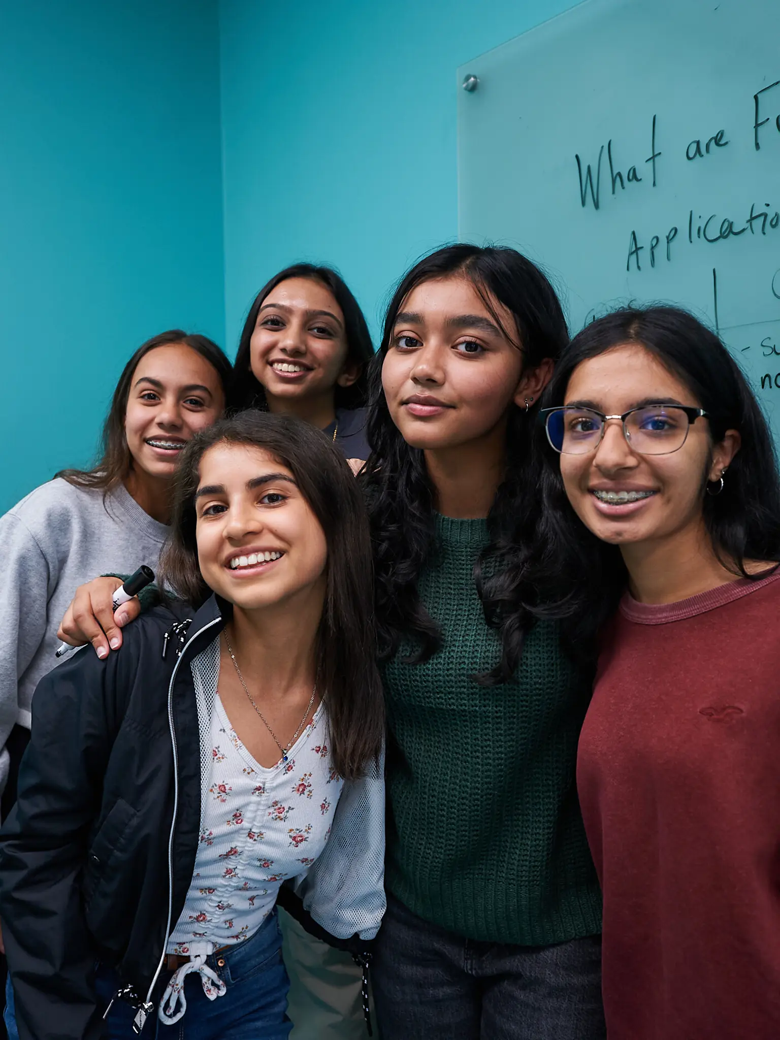 students pose in class at the blackboard
