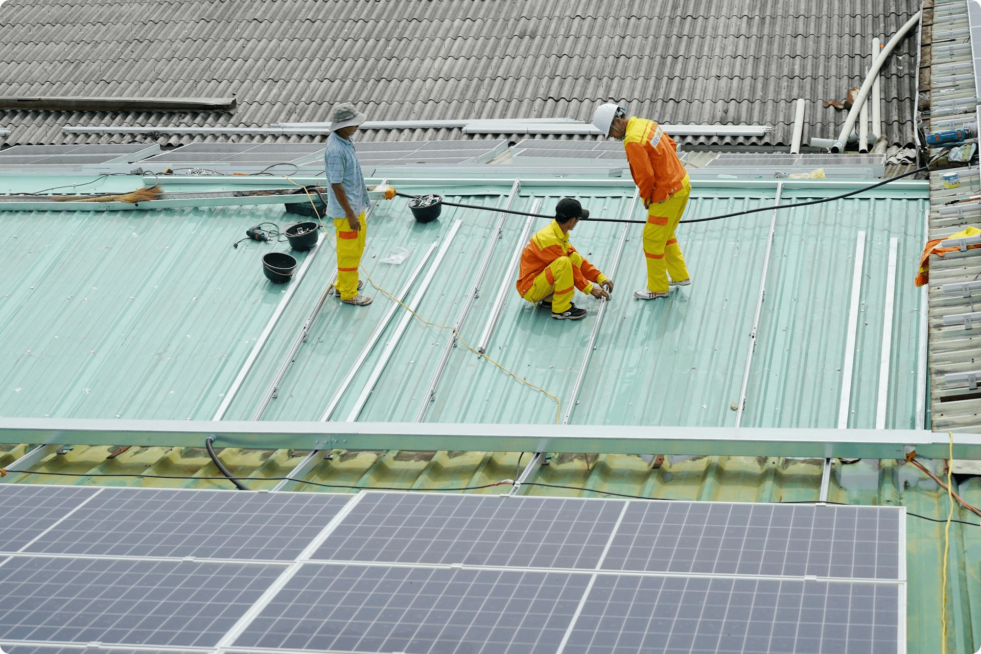 Workers preparing the installation of solar panels on the rooftop.
