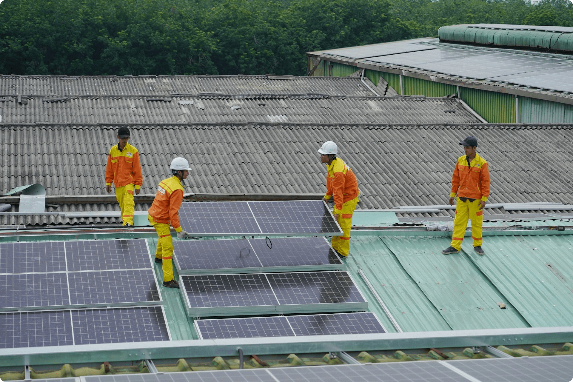 Workers on a rooftop installing solar panels.