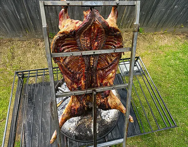 Lamb on a rack cooked over a fire pit