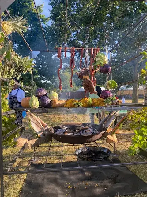 Meat and vegetables cooking on a fire cage