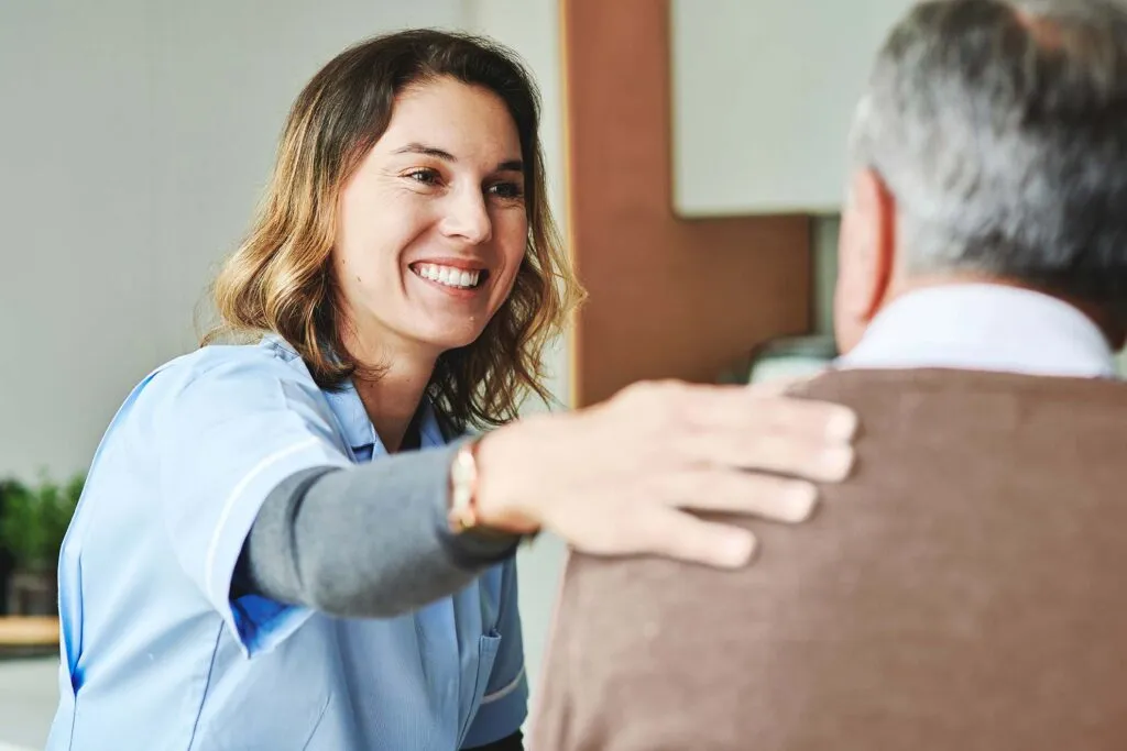 NDIS support worker smiling and giving reassurance to a participant.