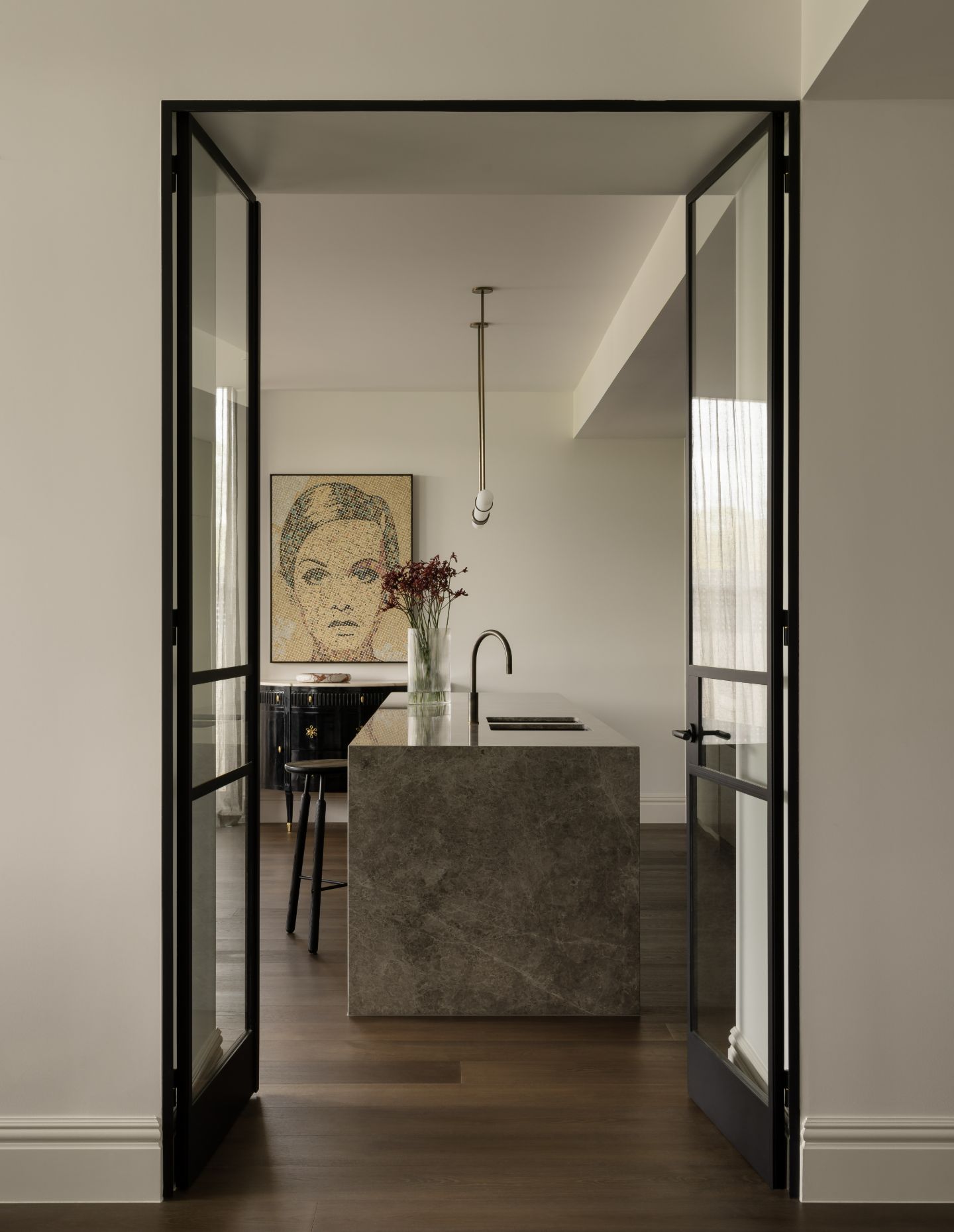 View through open doors into a kitchen within an architectural home in Melbourne.