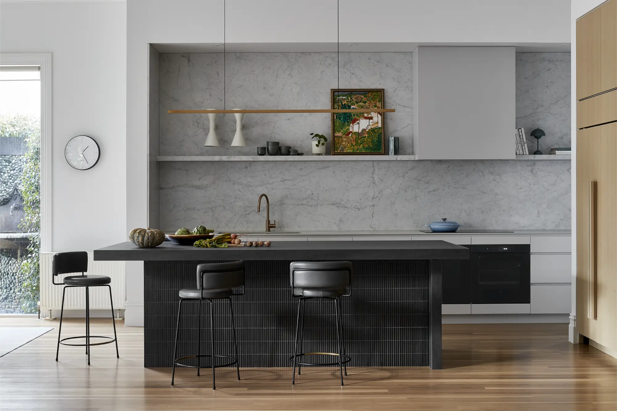 Modern marble kitchen with a black island bench and custom cabinetry in a high-end Melbourne home.