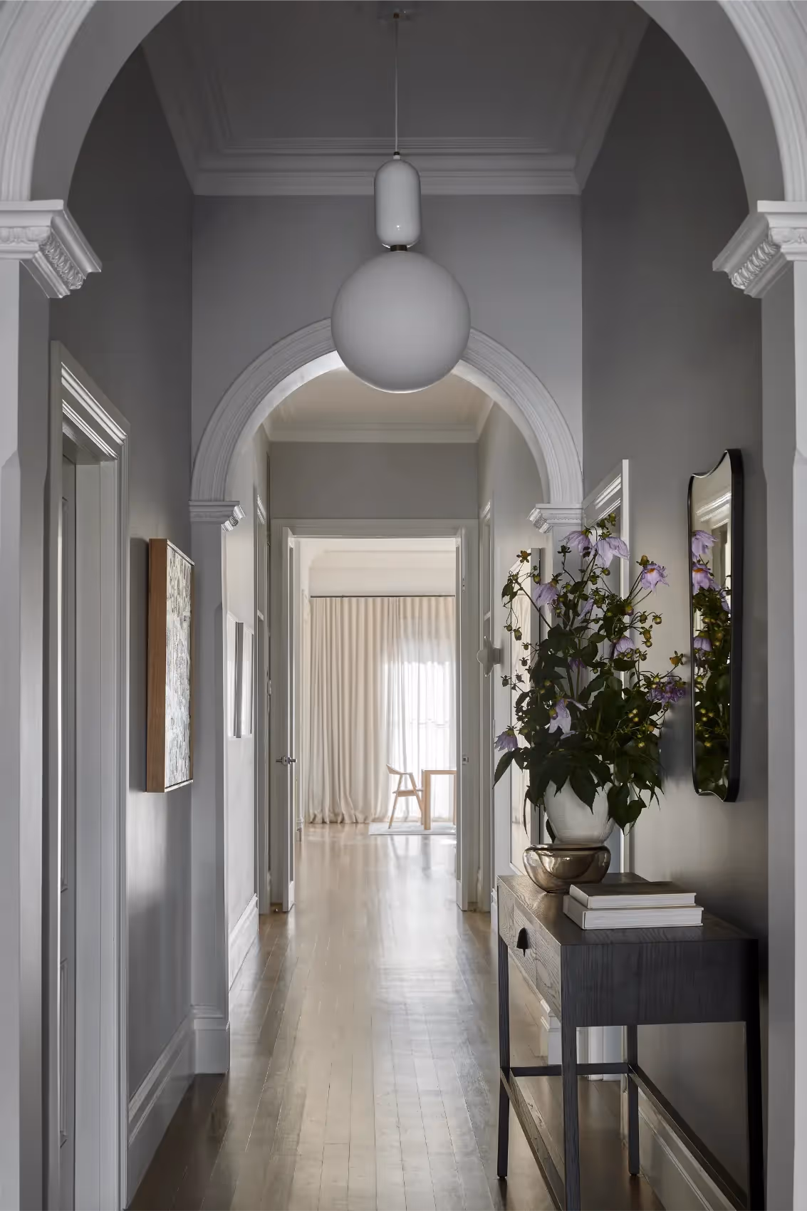 Hallway with arched openings and natural light in an architectural home in Melbourne.