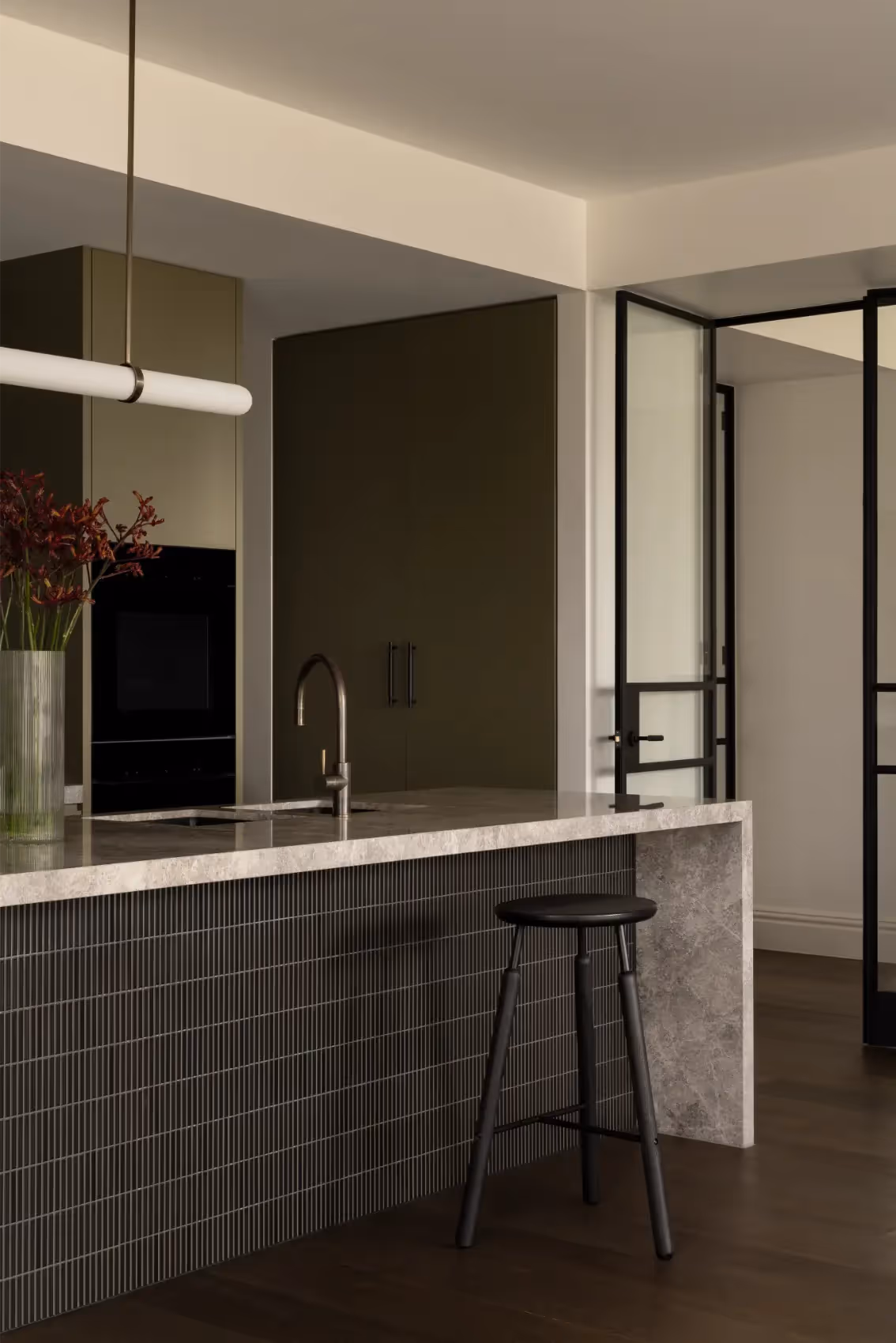 Kitchen island with stone benchtop and cabinetry in an architectural home in Melbourne.